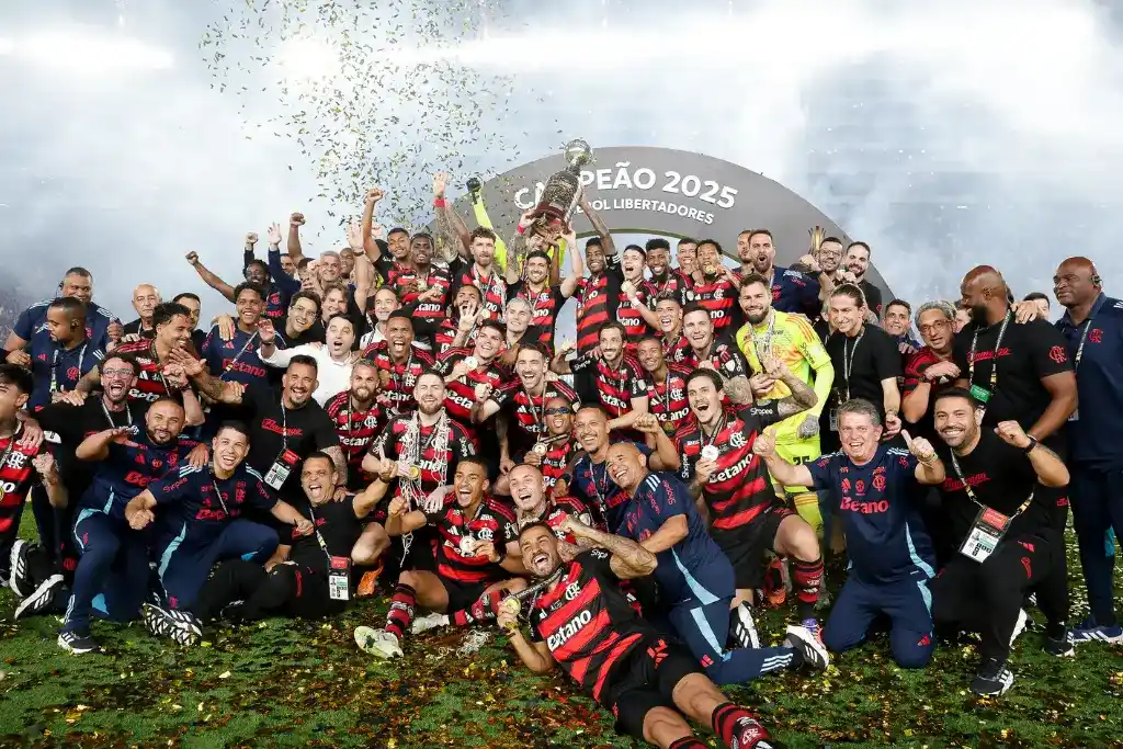 Jogadores e comissão técnica do Flamengo celebram o título de campeão de 2025 no pódio sob chuva de confetes, consolidando a posição do time entre os clubes com mais finais de Libertadores disputadas e vencidas recentemente.